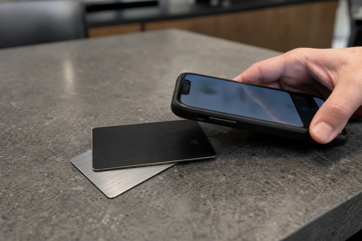 Metal NFC business card used beside a smartphone
