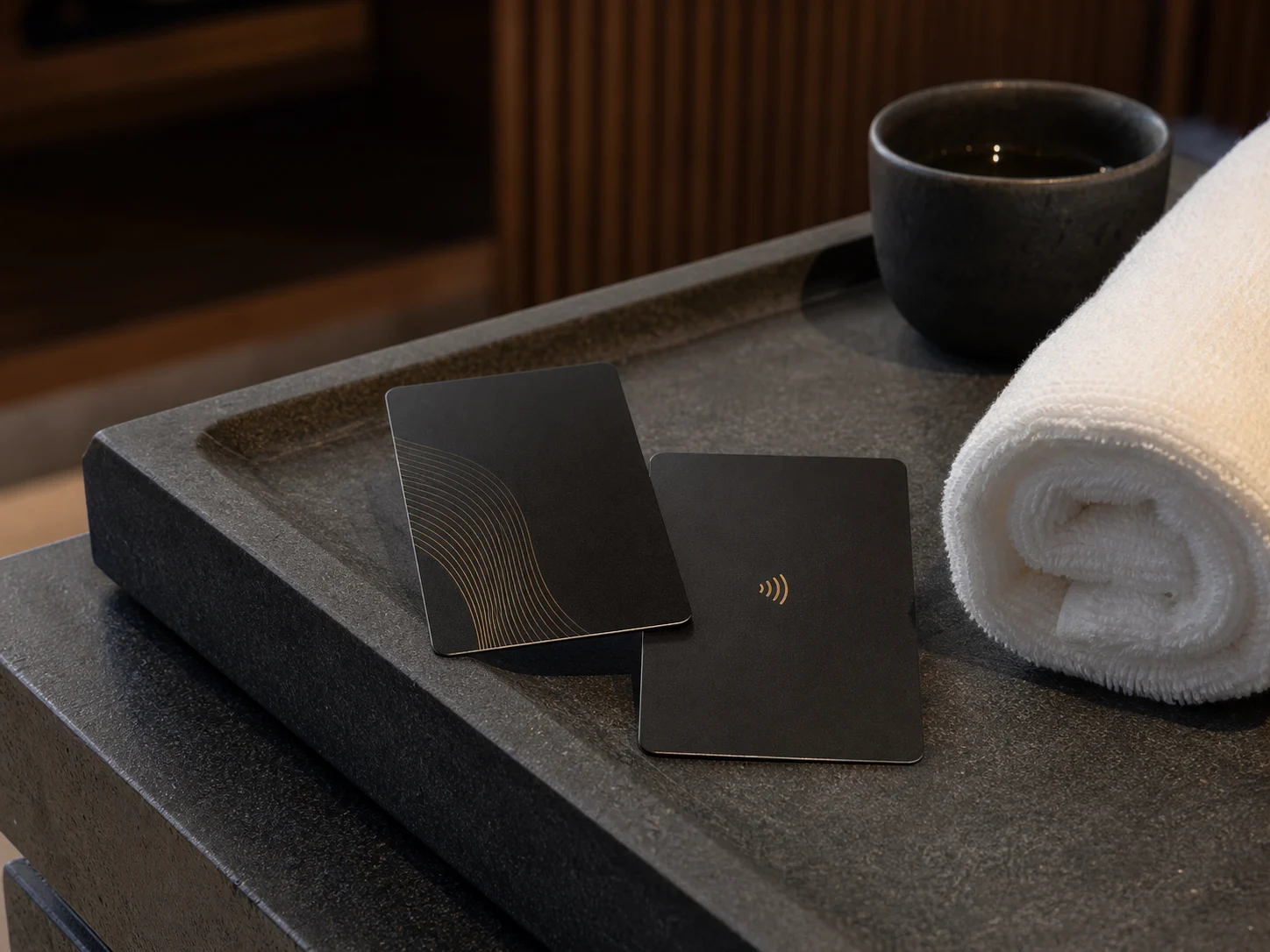Matte-black metal hotel key cards on a luxury spa tray