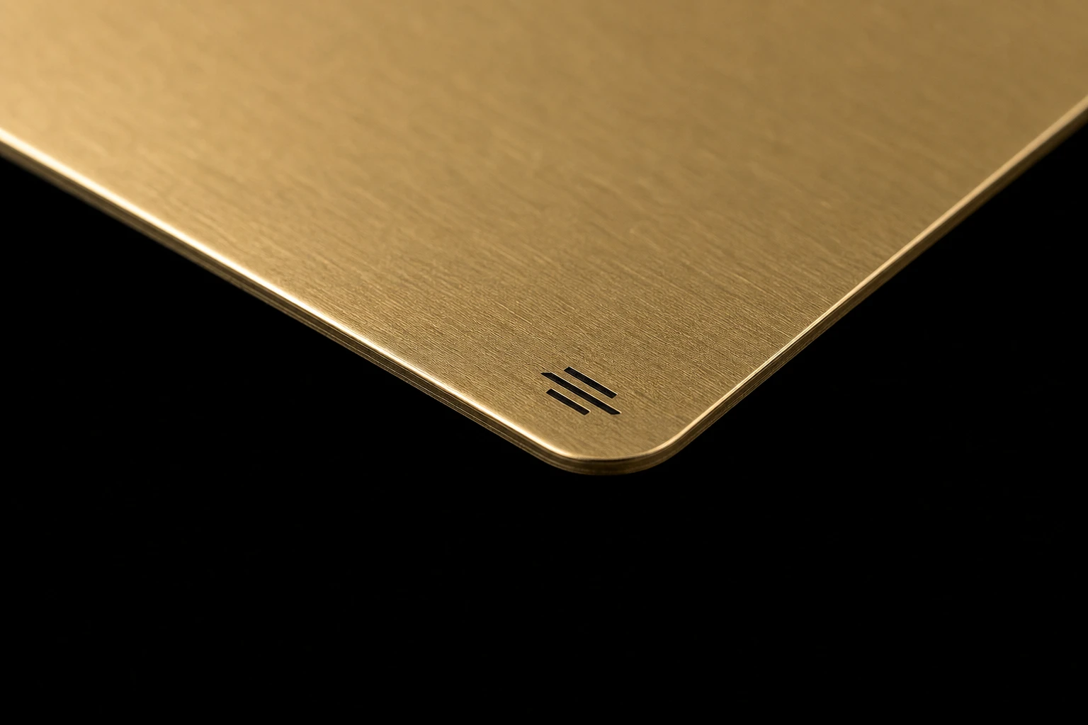 Thin brass card with a small dark enamel mark