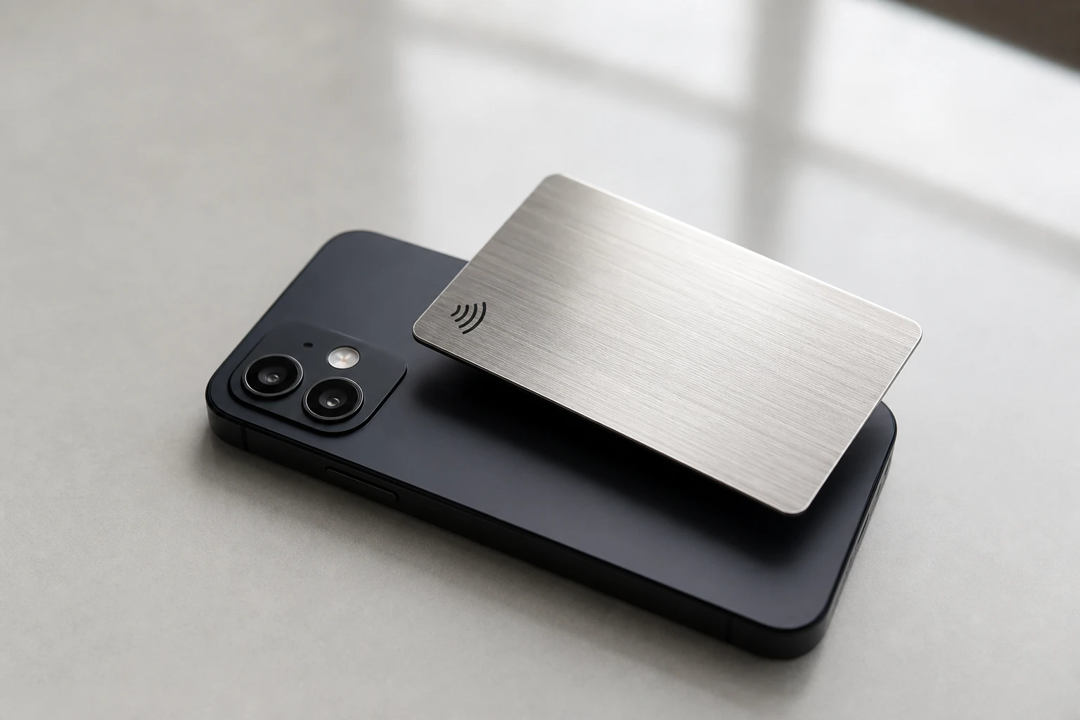 Brushed metal NFC card tapping a smartphone